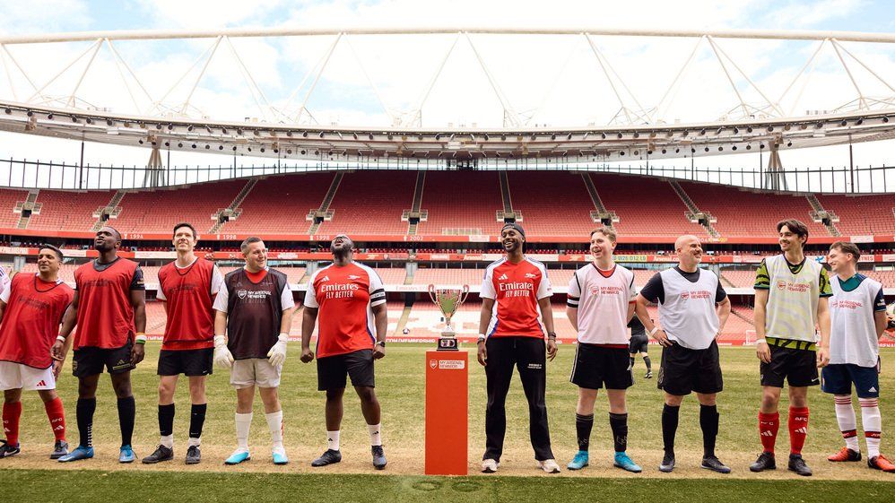 Members line up on the Emirates Stadium pitch